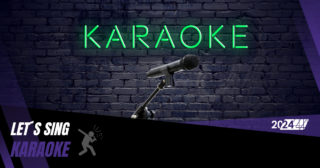 Ein Mikrofon steht vor einer dunklen Wand. Auf der Wand steht in grüner Neonschrift Karaoke.